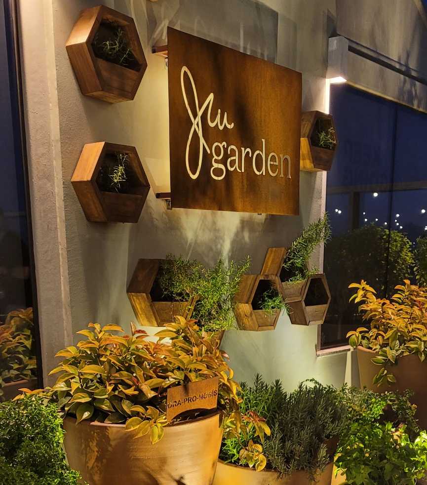 Foto mostra o JW Garden, espaço com vasos com temperos plantados.
