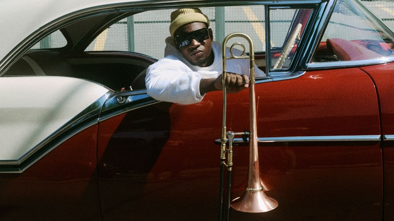 Joabe num carro vermelho segura seu instrumento musical